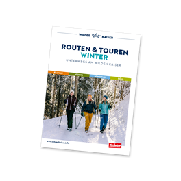 Ein Magazincover mit dem Titel "Routen & Touren". Auf dem Bild sind Menschen beim Wandern im verschneiten Wald zu sehen.