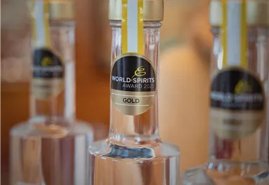 Eine Nahaufnahme von Flaschen mit Goldmedaille des World Spirits Award 2023. Die Flaschen sind klar und elegant, mit einem auffälligen Etikett.