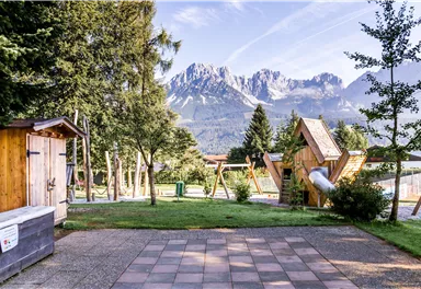Ein schöner Spielplatz mit einem Blick auf die Berge. Die Umgebung ist gepflegt und lädt zum Entspannen ein.