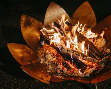 A beautiful fire in a decorative fire basket. The flames dance over the burning wood.