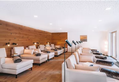 A quiet relaxation room with comfortable loungers. The walls are made of wood and the room is well lit.