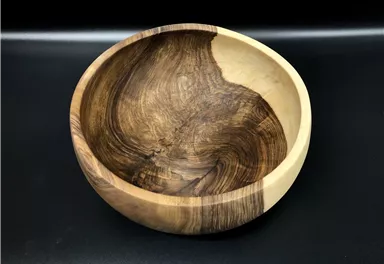 A beautiful wooden bowl with a unique grain pattern. The bowl has a clear contrast between light and dark wood areas.