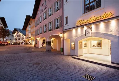 A picturesque square with historical buildings and a cinema. The evening atmosphere creates an inviting ambiance.