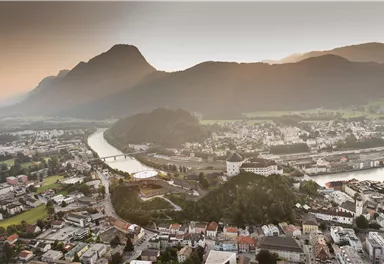 A picturesque landscape with a river and surrounded by mountains. The town lies idyllically in the valley, encircled by nature.