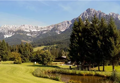 Eine malerische Landschaft mit Bergen im Hintergrund und einem ruhigen Teich. Die Umgebung ist grün und üppig, ideal für Outdoor-Aktivitäten.