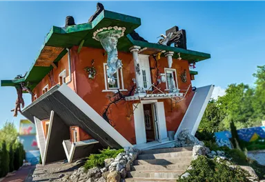 An unusual house with a slanted design and colorful facade. It attracts attention with its creative architecture.