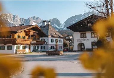 A picturesque village with traditional wooden house architectures and mountains in the background. The scenes convey a calm, alpine atmosphere.