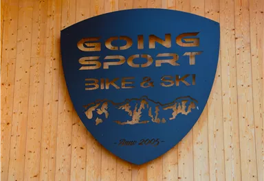 A black sign with the inscription "GOING SPORT BIKE & SKI". It features a mountain silhouette and the founding year 2005.