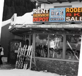 A sports shop in the snow that rents and sells ski equipment. In the background, a ski lift is visible.