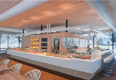 A modern restaurant with a large buffet area and bright wooden elements. The tables and chairs are stylish and invite you to linger.