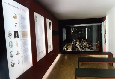 A modern museum with wall panels and displayed objects. The space is bright and inviting.
