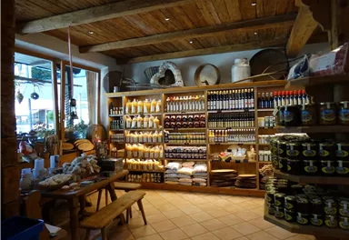 A cozy shop with shelves full of bottles and jars. Wooden shelves and tables create an inviting atmosphere.