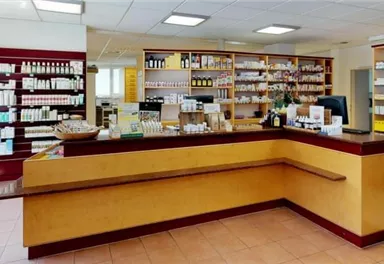 Eine helle Apotheke mit Regalen voller Medikamente. Der Empfangstresen ist gut sichtbar und freundlich gestaltet.