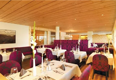 An elegant restaurant with stylish tables and comfortable seating. The warm wood walls and tasteful decoration create an inviting atmosphere.