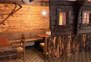 A rustic interior design with wooden beams and a patterned floor. The room has an inviting and cozy atmosphere.