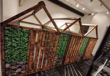Eine kreative Holzstruktur mit Pflanzenmotiven. Sie sieht aus wie ein kleines Gebäude mit einem rustikalen Design.