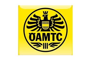 Ein gelbes Logo mit einem schwarzen Wappen, das einen Adler zeigt. Darunter steht in großen Buchstaben „ÖAMTC“.