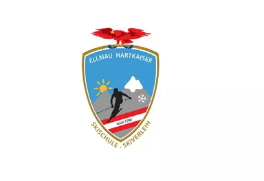 A coat of arms featuring a skier, a mountain, and a snowflake. Above it is a red eagle and the inscription “Ellmau Hartkaiser Ski School - Ski Rental.”