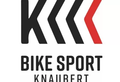 Ein Logo für "Bike Sport Knaubert". Es zeigt stilisierte Pfeile und den Schriftzug in klarer, moderner Schrift.