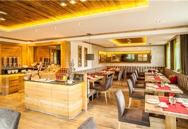 A modern restaurant with wooden paneling and elegant tables. The atmosphere is cozy, ideal for a relaxed meal.