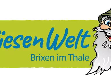 The image shows the logo of RiesenWelt Brixen im Thale. It features a friendly, bearded character in a hat and the lettering in vibrant colors.
