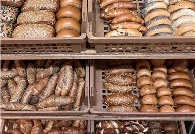 A selection of various bread rolls in baskets. The bread rolls are arranged in different shapes and varieties.