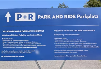 An information sign for the P+R parking lot in Scheffau. It contains instructions for the use and payment of the parking lot.