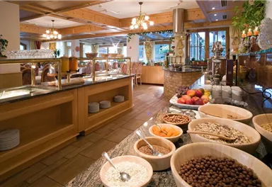 An inviting buffet with various breakfast ingredients such as cereals, nuts, and fresh fruit. The room is bright and friendly, with a rustic ambiance.