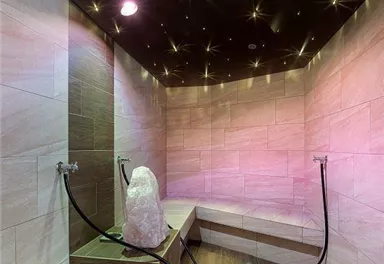 A modern steam bath area with soft lighting and wooden paneling. A stylish atmosphere invites you to relax.