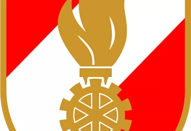Ein Wappen mit einem roten und weißen Muster. In der Mitte befindet sich eine goldene Flamme über einem Zahnrad.