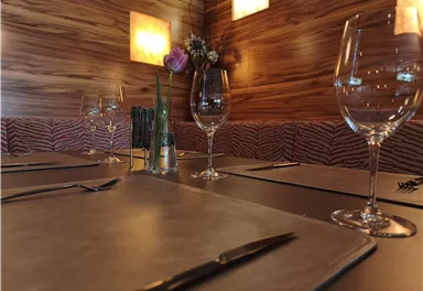Eine stilvolle Bar mit einer Willkommensnachricht auf einer Tafel. Auf dem Tresen stehen Flaschen, umgeben von modernem Interieur.