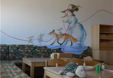 A cheerful mural depicts a snowman leading a fox and a mouse on a leash. The room is bright and inviting with colorful furniture and toys.