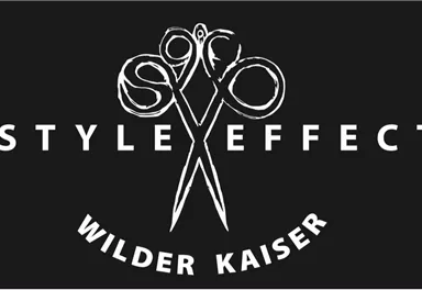 Ein schlichtes Logo mit einem Paar Scheren und dem Schriftzug "STYLE EFFECT WILDER KAISER". Der Hintergrund ist schwarz und hebt die weißen Elemente hervor.