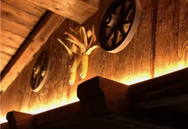 A rustic wooden decor with decorative wheels and a corn depiction. Gentle light highlights the texture of the wood.