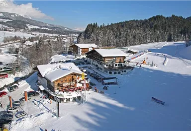 A picturesque ski resort with snow-covered hills and charming cabins. The sunny winter landscape invites you to ski and relax.