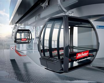 A modern cable car station with two gondolas. The surroundings depict an alpine landscape and are suitable for winter sports.