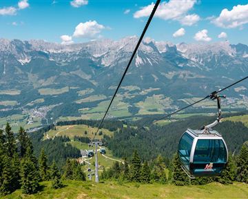 Blick aus einer Gondel der Brandstadlbahn auf das Bergmassiv des Wilden Kaisers und das grüne Tal.