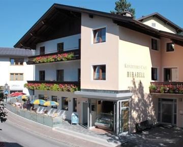 A cozy café with flowered balconies and sunny terraces. The surroundings are picturesque and inviting.