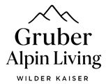 Logo of Gruber Alpin Living with mountain symbol and the lettering "Wilder Kaiser". It conveys a sense of connection to nature and alpine style.