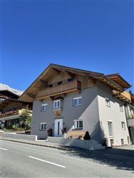 Ein modernes, zweigeschossiges Haus mit Holzelementen. Der klare blaue Himmel ergänzt die attraktive Architektur.