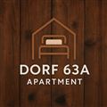 A stylish logo for the apartment "Dorf 63A". It features a simple house symbol and is placed on a wood background.