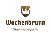 Ein elegantes Logo mit dem Schriftzug "Wochenbrunn". Darunter steht der Slogan "Mit dem Kaiser per Du".