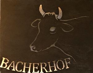 Ein schlichtes Logo mit dem Kopf einer Kuh. Der Schriftzug „Bacherhof“ ist darunter platziert.