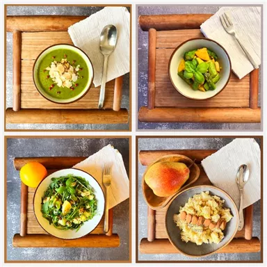 Verschiedene gesunde Gerichte auf Holztabletts. Dazu gehören grüne Suppe, Obstsalat, gemischter Salat und Quinoa mit Nüssen.
