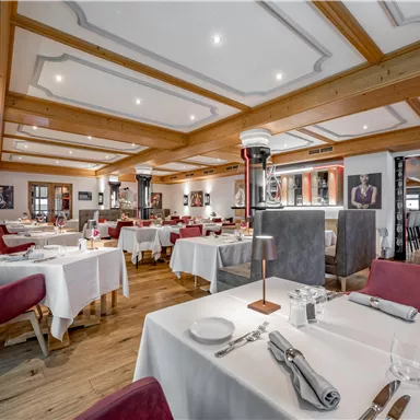 An elegant restaurant with modern furniture and stylish ambiance. The tables are carefully set and invite patrons to linger.