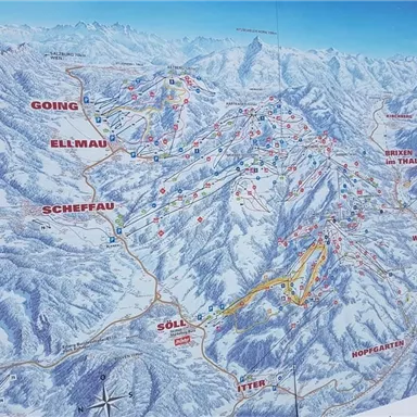 Eine detaillierte Karte eines Skigebiets mit verschiedenen Pisten und Gondelstationen. Im Hintergrund sind schneebedeckte Berge zu sehen.