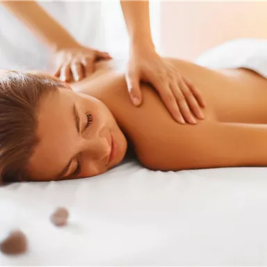 A relaxing massage with a woman lying on a treatment table. The atmosphere is calm and pleasant.