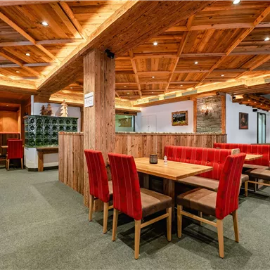 Ein gemütliches Restaurant mit Holzdekor und roten Stühlen. Die Atmosphäre ist einladend und warm.