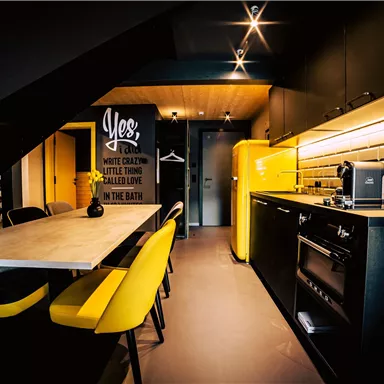 A modern kitchen with a yellow refrigerator and stylish furniture. The room has a cozy atmosphere and is well-lit.