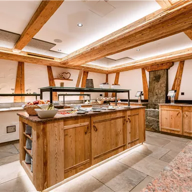 Eine moderne Küche mit Holzregalen und einem Buffet. Die Atmosphäre ist warm und einladend.